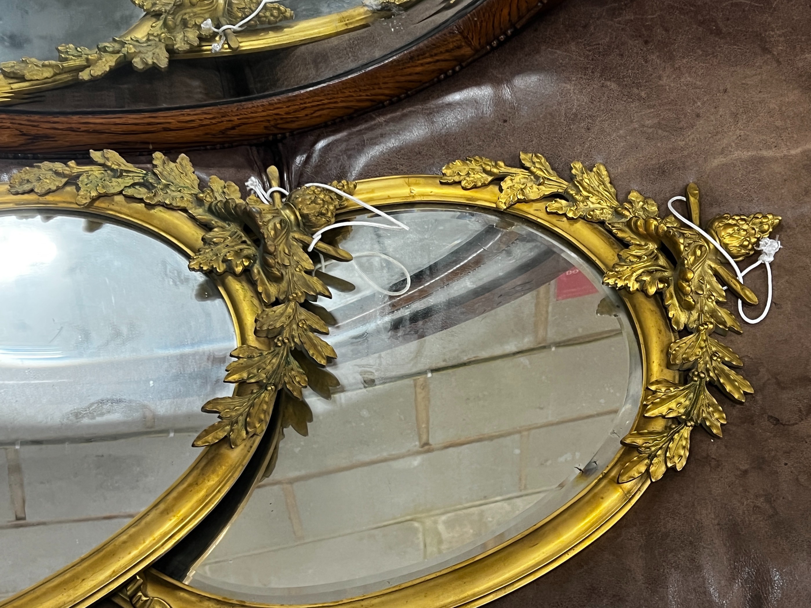 A pair of oval brass framed wall mirrors, width 36cm, height 71cm